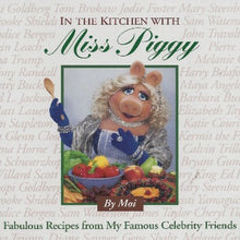 Load image into Gallery viewer, In the Kitchen with Miss Piggy.  Miss In the Kitchen with Miss Piggy is a collection of recipes from some of Miss Piggy&#39;s 50 closest friends, including Clint Eastwood, Harry Belafonte, Lena Horne, Tony Randall, John Travolta, and Kermit the Frog. She supplies her own brand of gourmet wit and wisdom. Piggy is displaying food made from recipes